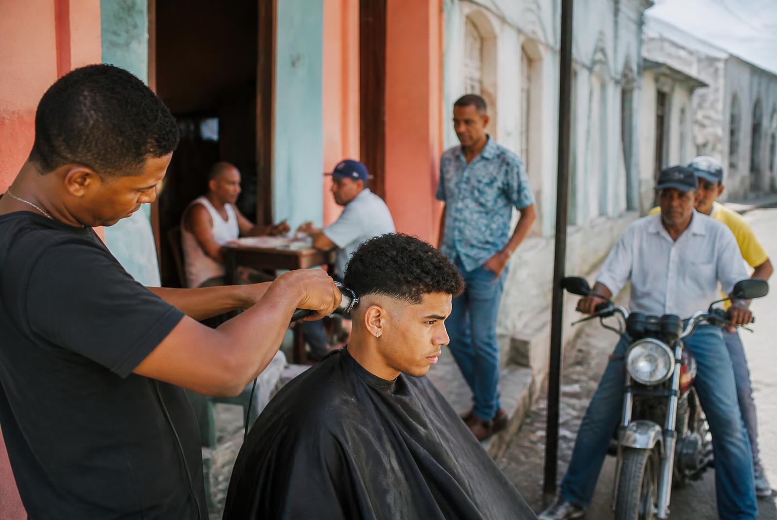 Street barbershop scene in Puerto Plata